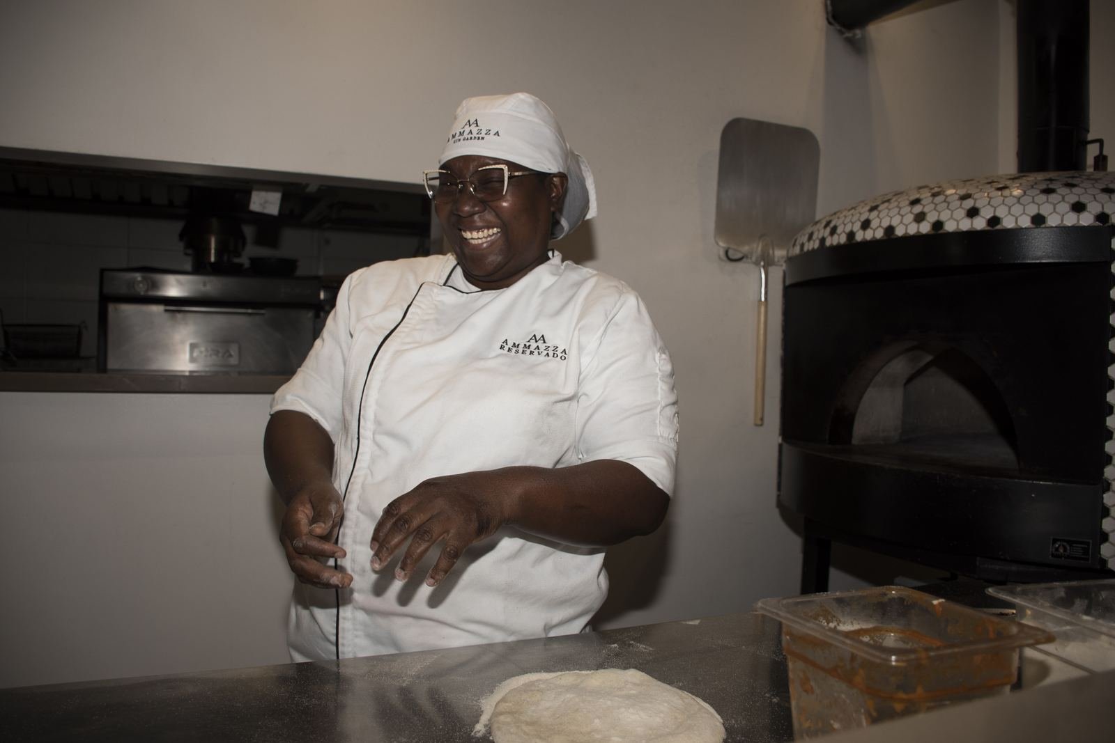 Cocinera con chaqueta y gorro con el logo del restaurante